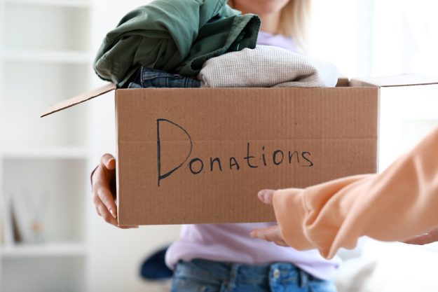 Young woman donating clothes in box at home Independent Living In Lely, FL: Three Volunteering Opportunities For Seniors