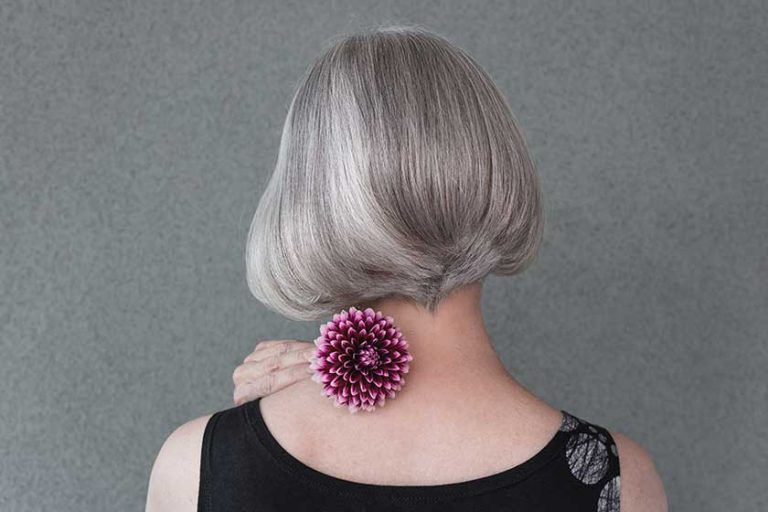 Lady with beautiful silver hair and red dahlia