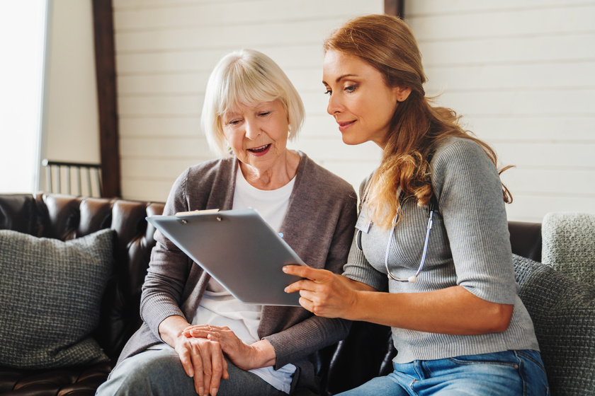 Senior old woman sits with middle aged nurse making notes at retirement house Making Mealtimes Easier For Dementia Patients: 7 Ways Memory Care In Bexar County, TX Can Help