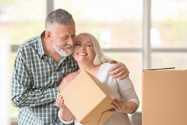 Mature couple with moving boxes at new home Mature couple with moving boxes at new home