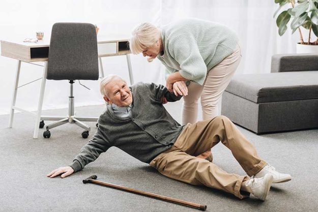 Old woman helping to stand up husband who falled down on floor