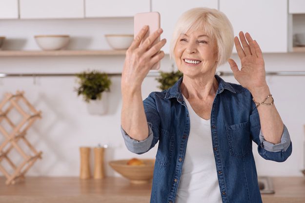 Positive senior woman talking via the Internet
