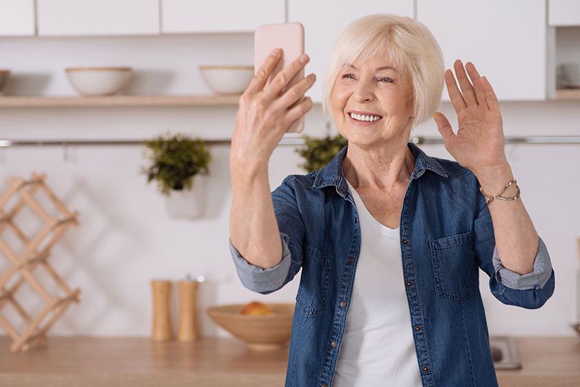 Positive senior woman talking via the Internet