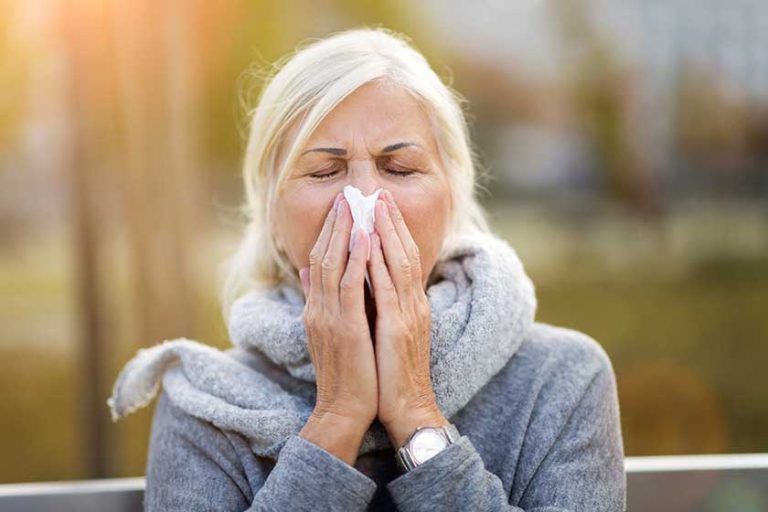 Sick woman blowing her nose