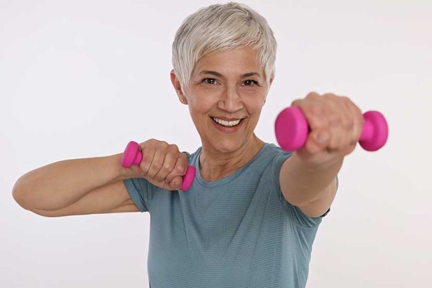 Smiling Sport Mature Woman holding dumbbells Smiling Sport Mature Woman holding dumbbells