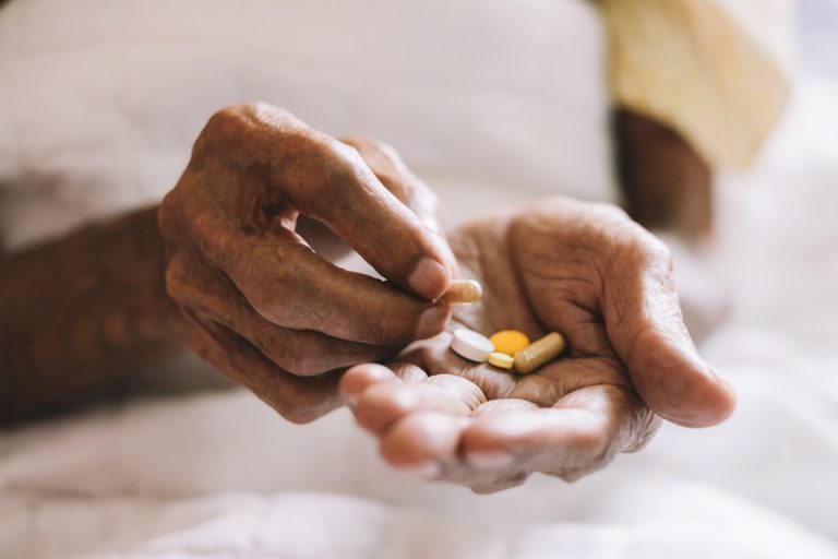 pills in a Senior’s hands. Painful old age. Caring for the healt What Vitamins Do You Need The Most In Your Senior Years?