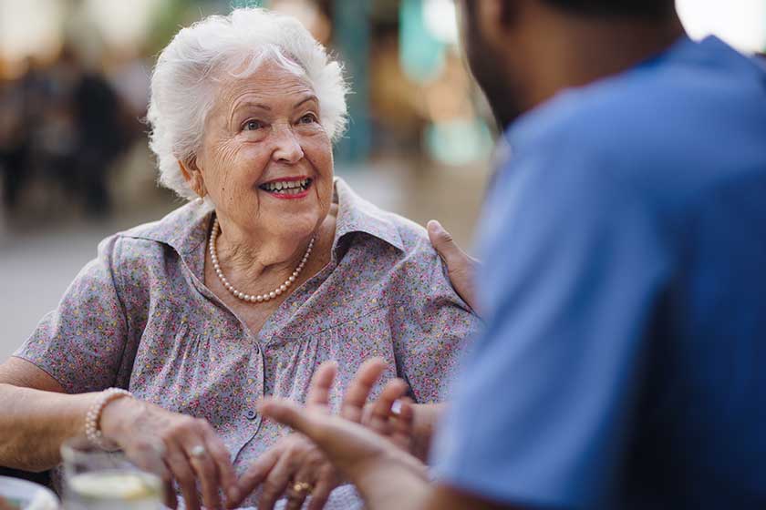 Caregiver talking with his client at cafe, having nice time together. Caregiver talking with his client at cafe, having nice time together.