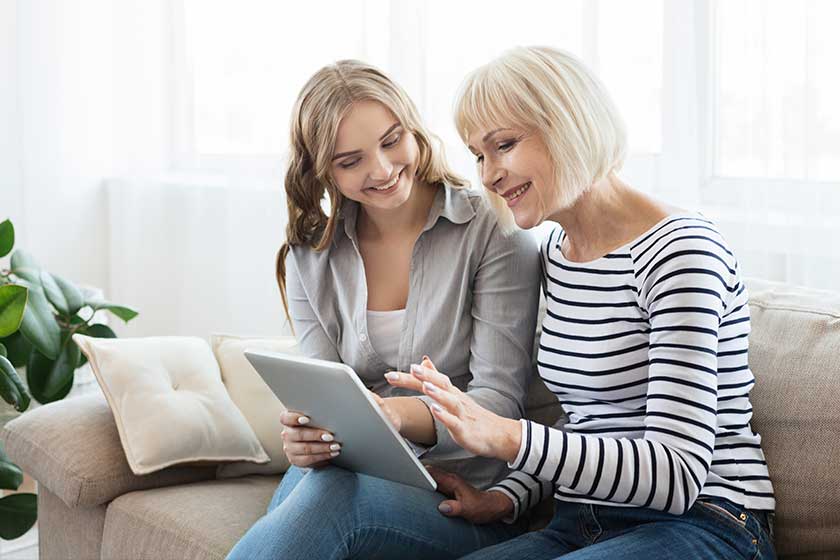 Daughter teaching senior mother to use tablet computer Daughter teaching senior mother to use tablet computer