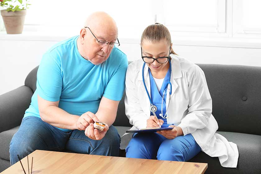 Doctor visiting senior diabetic man at home