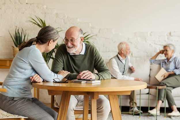Elderly man and woman sitting at table and enjoying joyful talk Elderly man and woman sitting at table and enjoying joyful talk