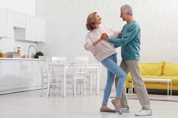 Happy senior couple dancing together in kitchen Happy senior couple dancing together in kitchen