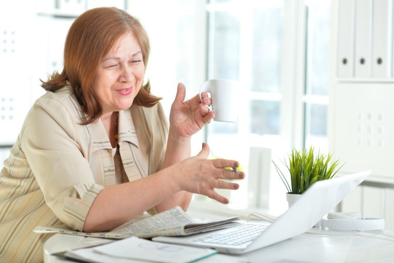 Portrait of senior woman working with laptop Independent Living Vs. 55+ Communities Near Arlington, TX: 5 Factors To Consider