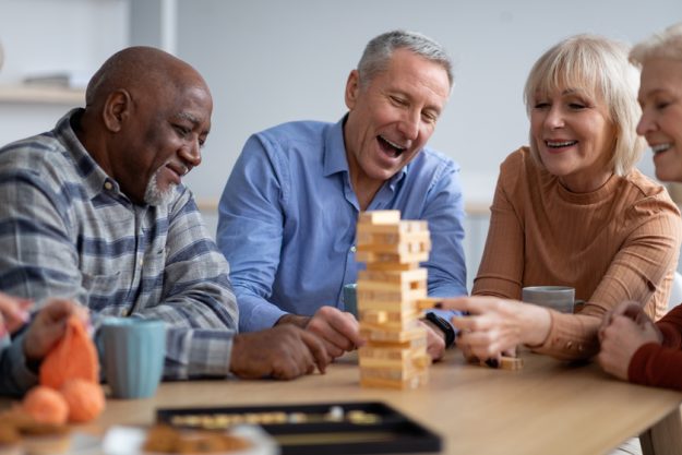Cheerful senior people paying table games together Cheerful senior people paying table games together