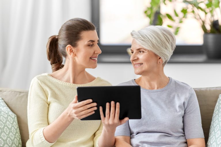 daughter and senior mother with tablet pc at home
