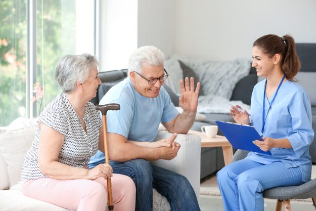 Elderly couple with caregiver in nursing home