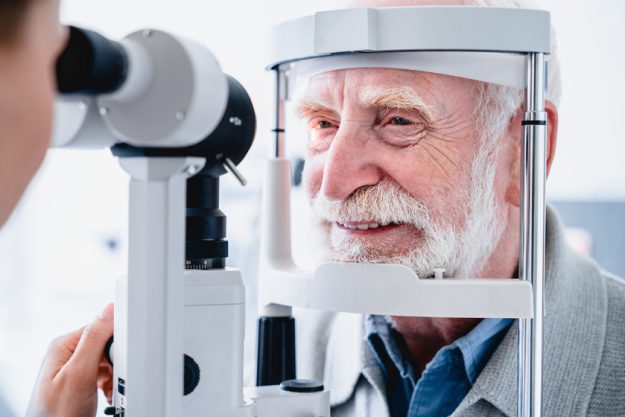 Close up photo of smiling senior male patient during sight examination Close up photo of smiling senior male patient during sight examination