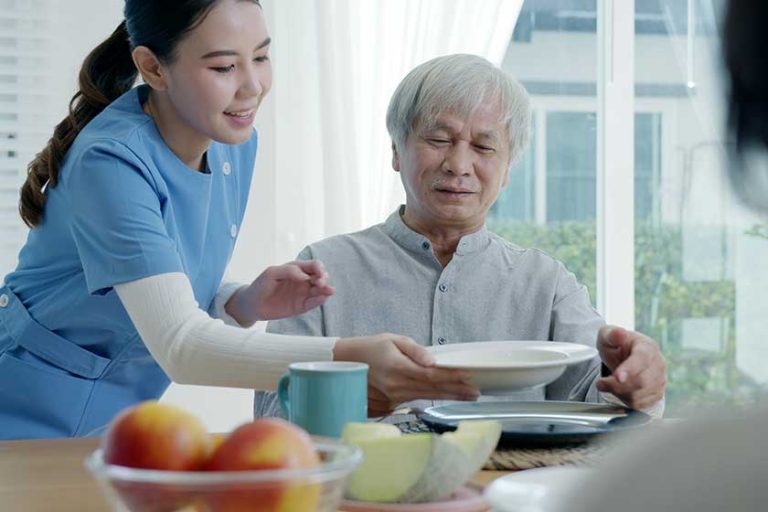 Attractive young senior asian citizen couple happy sit, talk, eat soup
