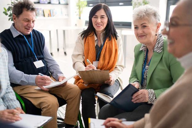 Excited elderly people attending group therapy session at nursing house Excited elderly people attending group therapy session at nursing house