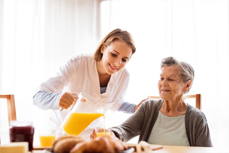 Health visitor and a senior woman during home visit.