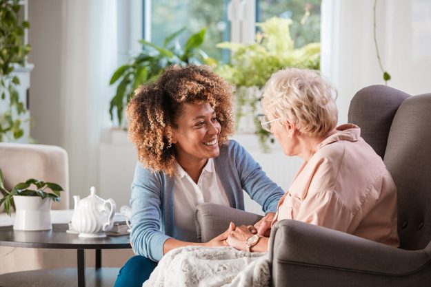Friendly nurse supporting an eldery lady