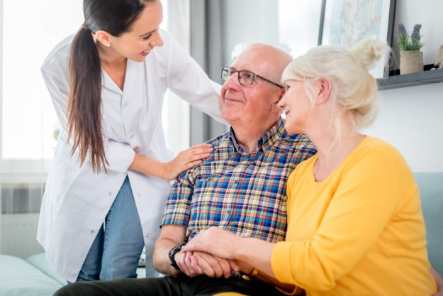 Smiling nurse talking with senior couple during home visit How Retirement Homes Around Dallas, TX Support Smart Aging