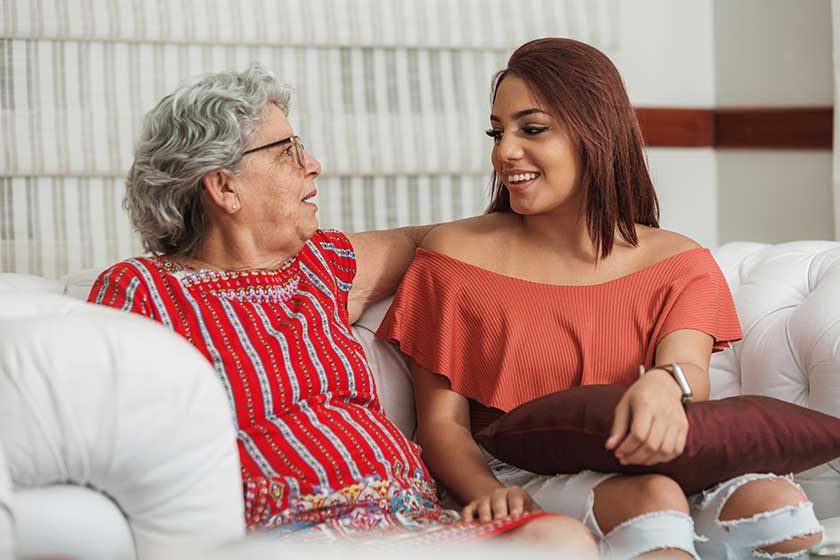 Mother and adult daughter chatting sitting in the living room Mother and adult daughter chatting sitting in the living room