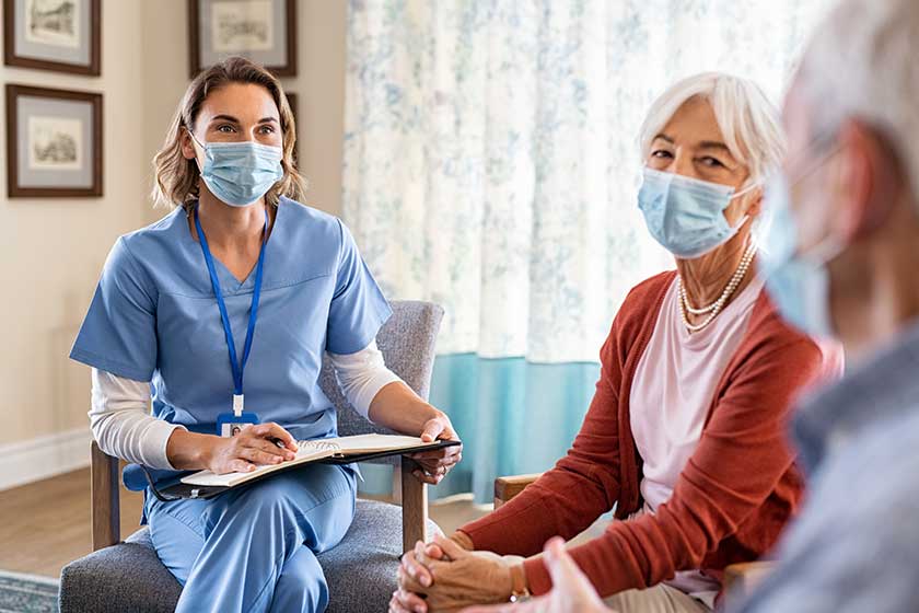 Nurse listening to senior couple during a home visit Nurse listening to senior couple during a home visit