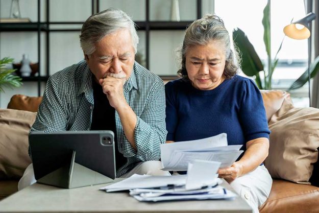 old retired asian senior couple checking and calculate financial billing together