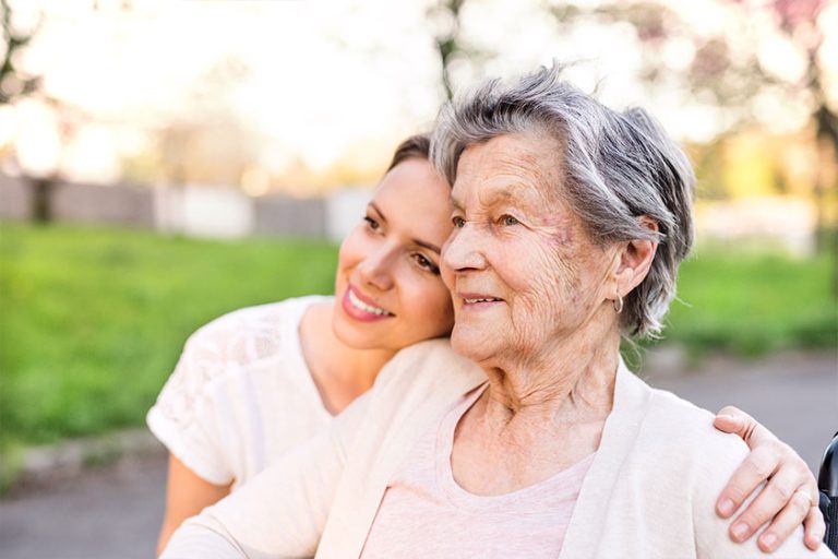 Elderly grandmother and granddaughter hugging in spring nature. Elderly grandmother and granddaughter hugging in spring nature.