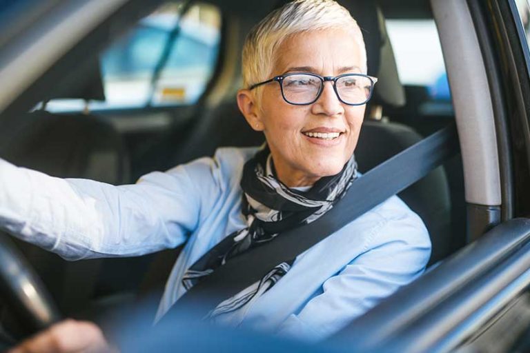 Happy and smiling senior woman in black car Happy and smiling senior woman in black car