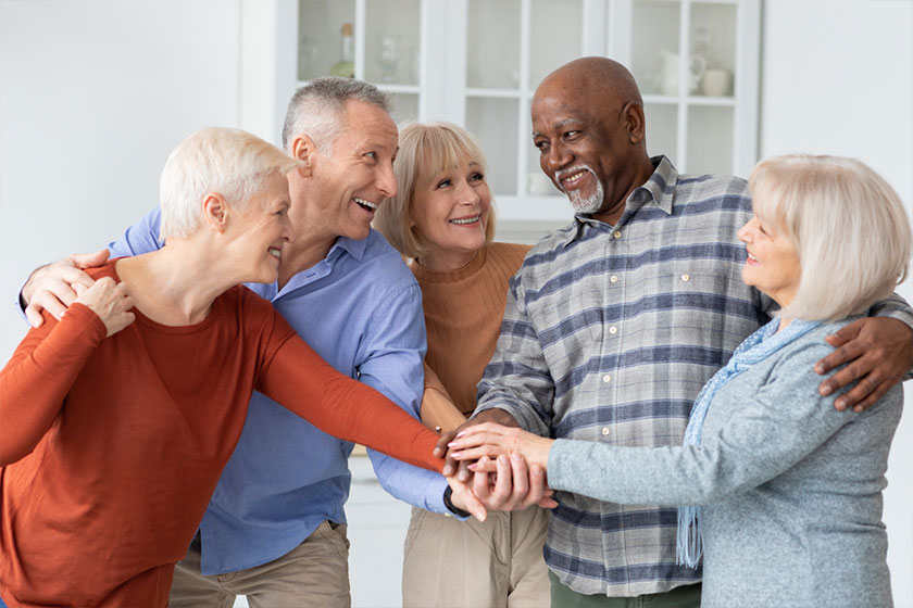 Multiethnic group of senior friends holding hands together Multiethnic group of senior friends holding hands together