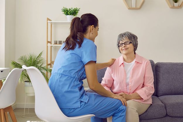 Young pretty nurse at home respectfully communicates with an elderly woman Young pretty nurse at home respectfully communicates with an elderly woman