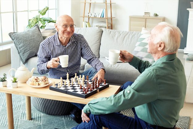 Elderly men playing chess at home Elderly men playing chess at home