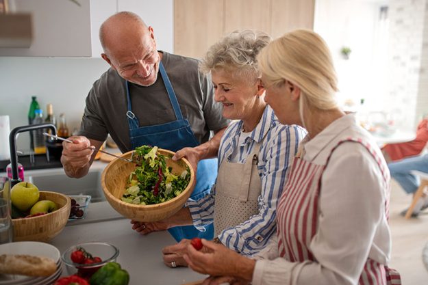 Group of senior friends having party indoors Group of senior friends having party indoors