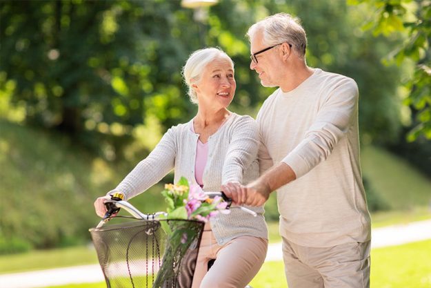 happy senior couple with bicycle at summer park happy senior couple with bicycle at summer park