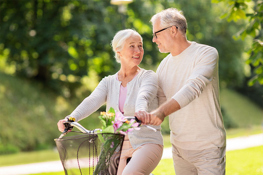 happy senior couple with bicycle at summer park happy senior couple with bicycle at summer park
