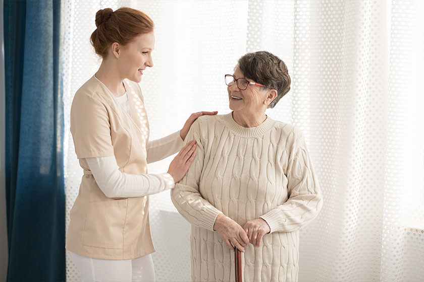 Professional caregiver assisting elderly woman