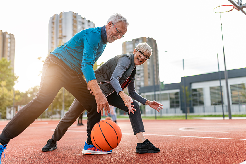 Cheerful active senior couple playing basketball Cheerful active senior couple playing basketball