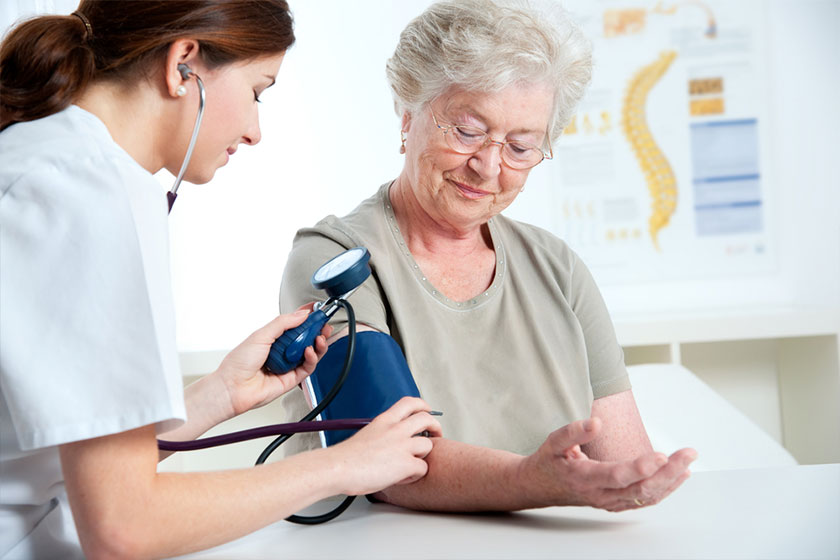 Doctor measuring arterial blood pressure of elderly patient with hypertension