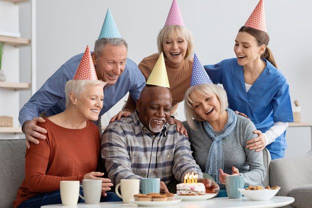 Elderly black man having birthday party at nursing home