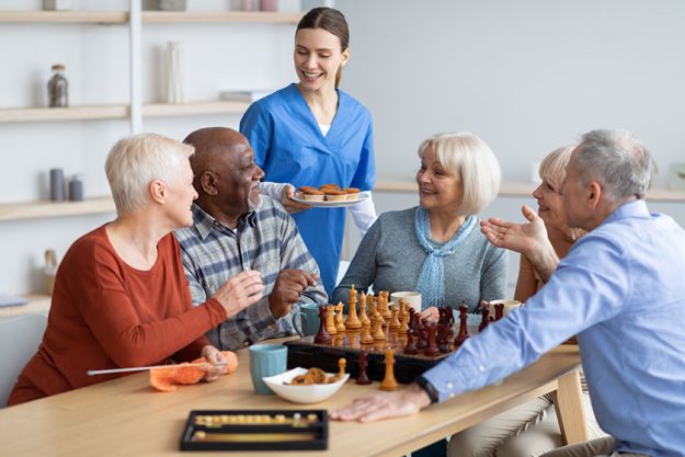 Friendly nurse holding plate with cupcakes Friendly nurse holding plate with cupcakes