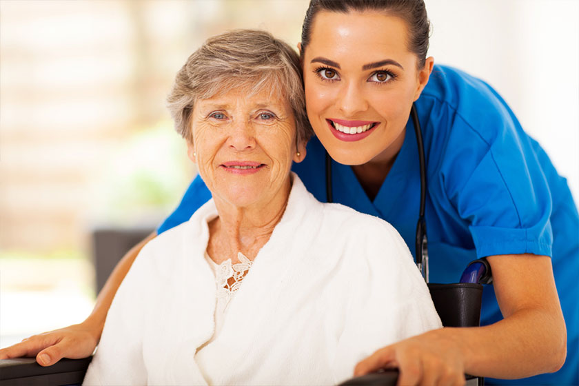 Happy beautiful senior woman together with her friendly young nurse