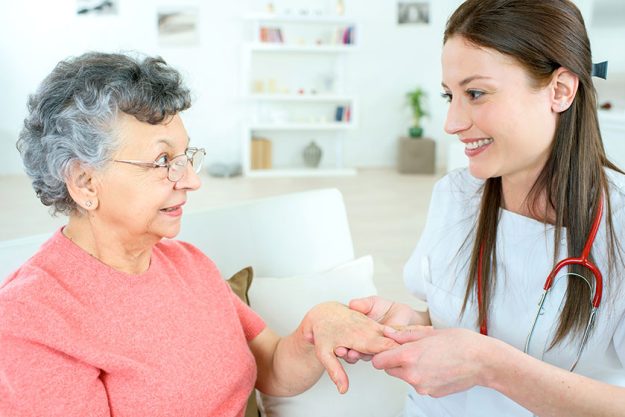 Nurse inspecting elderly lady’s hand Nurse inspecting elderly lady's hand