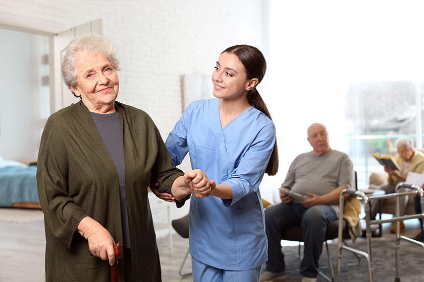 Nurse taking care of elderly woman in geriatric hospice