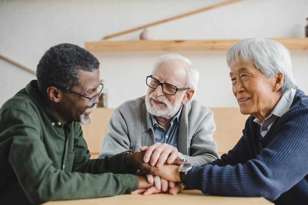 Senior friends making team gesture