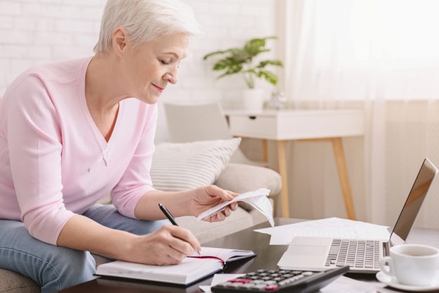Senior woman bookkeeping bills and payments at home Your Guide To Planning For The Unexpected Cost Of Healthcare