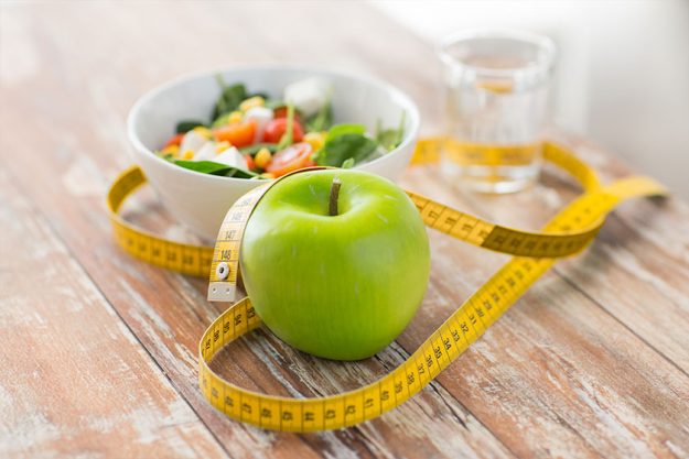 Close up of green apple and measuring tape