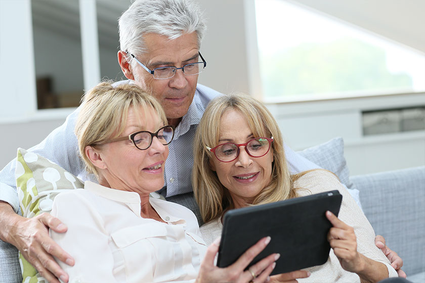 Friends with eyeglasses using digital tablet Friends with eyeglasses using digital tablet