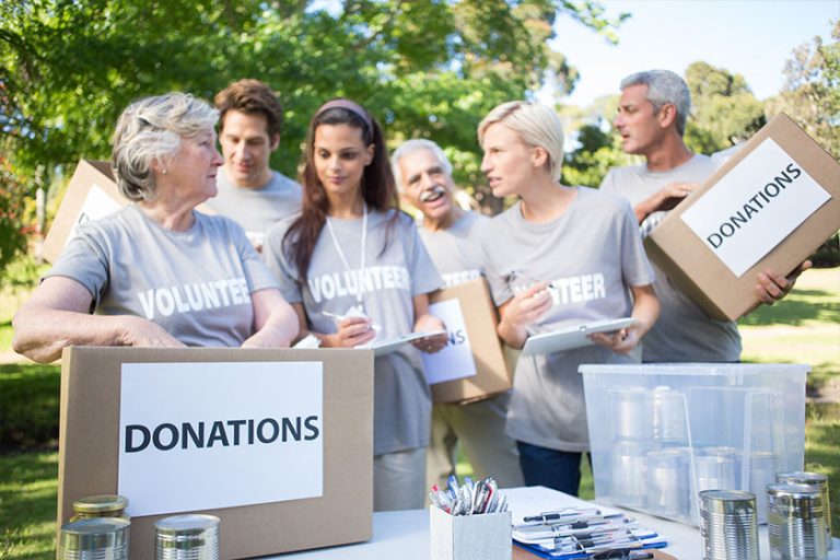Happy volunteer family holding donation boxes Happy volunteer family holding donation boxes