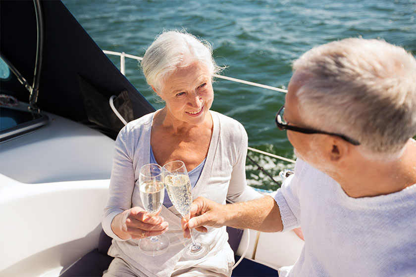 Senior couple clinking glasses on boat